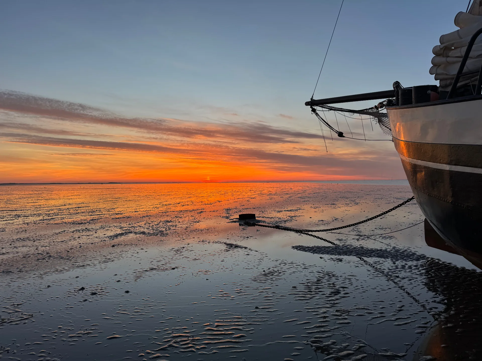 Ship bow on mudflats at sunset