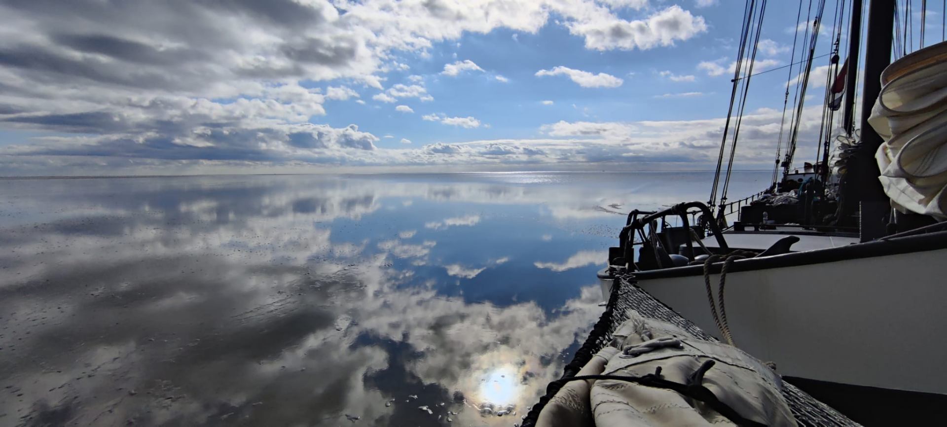 Mirror-calm Wadden Sea with clouds