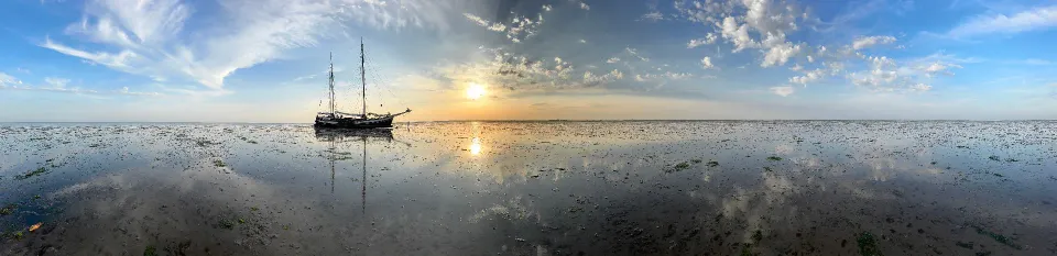 Wattpanorama mit der Minerva und der untergehenden Sonne